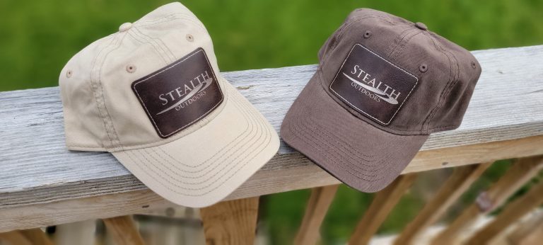 Khaki and brown dad hats with Stealth Outdoors logo